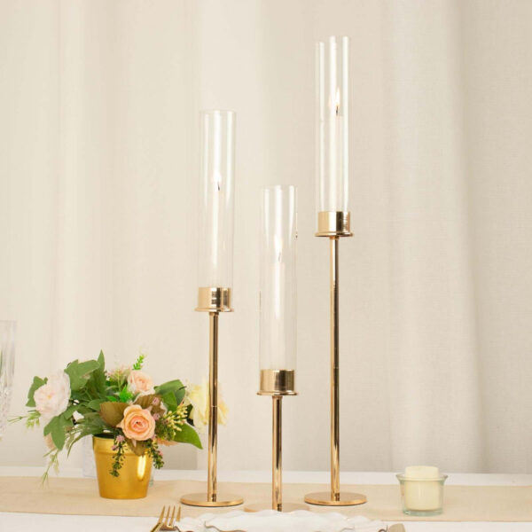 Set of 3 Tall Gold Metal Clear Glass Taper Candlestick Holders, Hurricane Candle Stands With Glass Chimney Candle Shades 16″, 20″, 24″